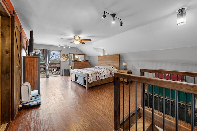 bedroom featuring lofted ceiling, ceiling fan, wood finished floors, rail lighting, and access to exterior