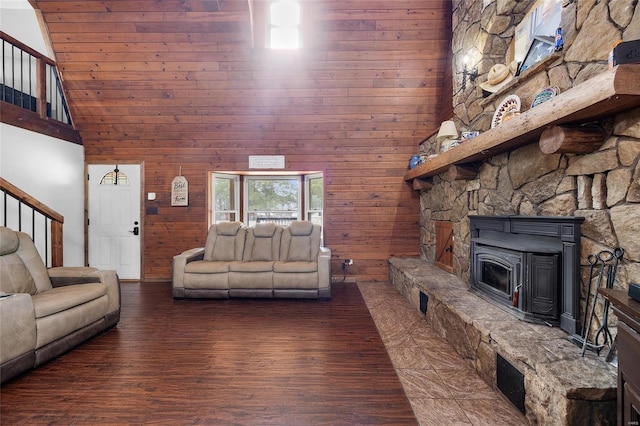 living room with a towering ceiling, wood walls, stairway, and wood finished floors