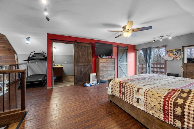 bedroom featuring a barn door and wood finished floors