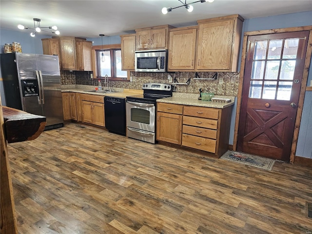 kitchen featuring decorative backsplash, appliances with stainless steel finishes, dark wood-style flooring, and a sink