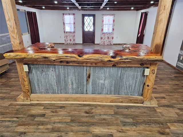 bar with a dry bar, wood finished floors, and baseboards