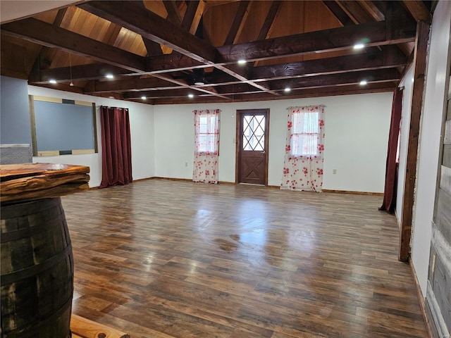 interior space featuring vaulted ceiling with beams, baseboards, and wood finished floors