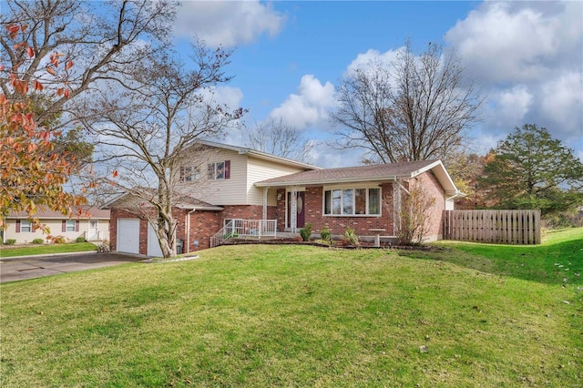 split level home with a garage, brick siding, fence, driveway, and a front yard