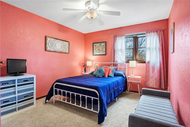 bedroom featuring a textured wall, a ceiling fan, and baseboards