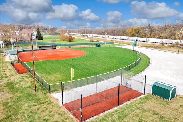 view of property's community featuring a tennis court and fence