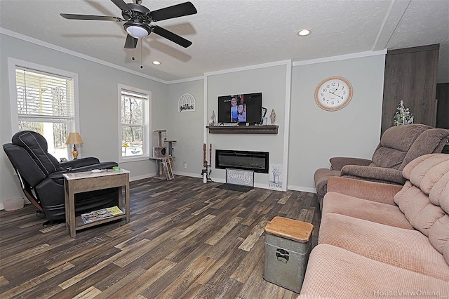 living room featuring a textured ceiling, baseboards, dark wood-style floors, a glass covered fireplace, and crown molding