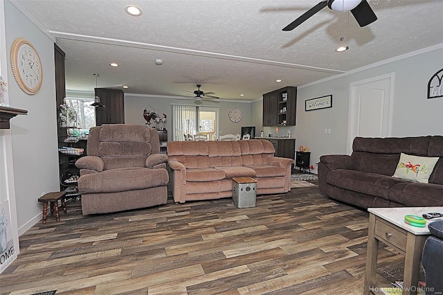 living area featuring a textured ceiling, ornamental molding, and dark wood-type flooring