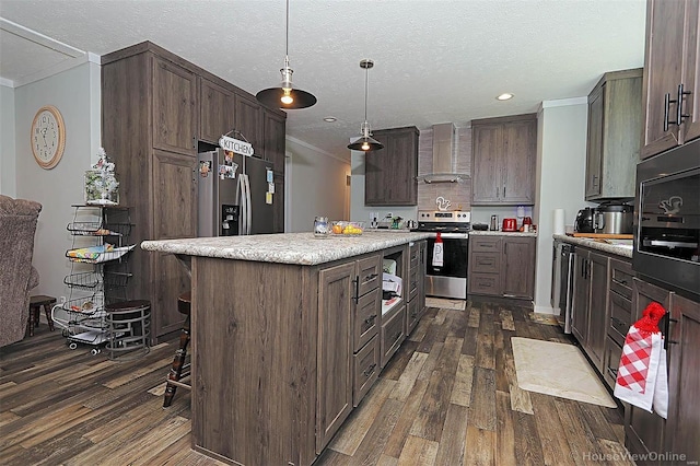 kitchen featuring stainless steel appliances, light countertops, a kitchen island, wall chimney range hood, and dark brown cabinets