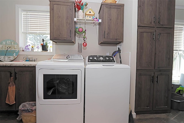 clothes washing area with cabinet space, a sink, and separate washer and dryer