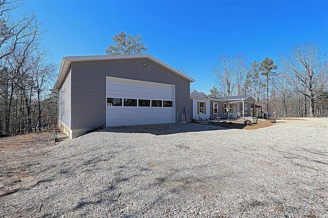 view of front of home featuring a porch, an outbuilding, driveway, and a garage