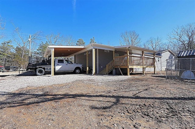 exterior space with driveway, an attached carport, and fence