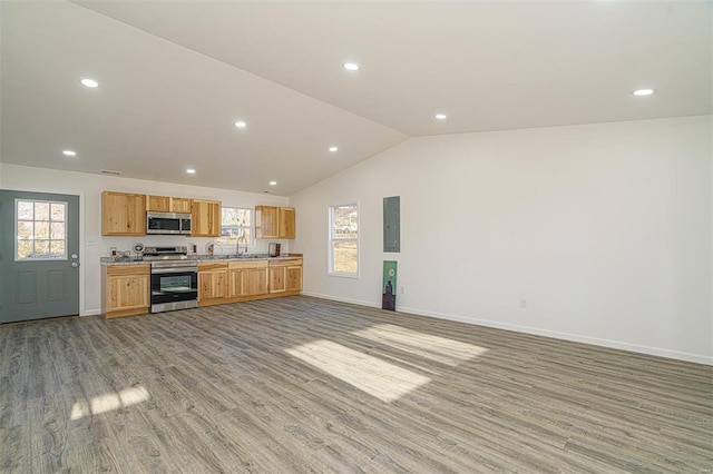 kitchen featuring baseboards, lofted ceiling, recessed lighting, appliances with stainless steel finishes, and light wood-type flooring