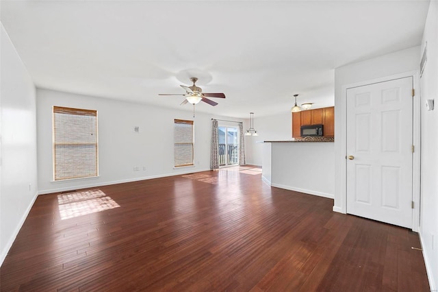 unfurnished living room with a ceiling fan, dark wood-style flooring, and baseboards