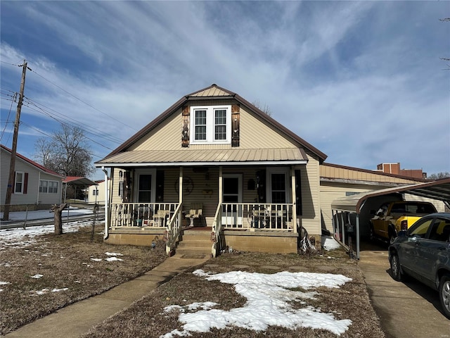 view of front of property featuring a porch, metal roof, and a carport