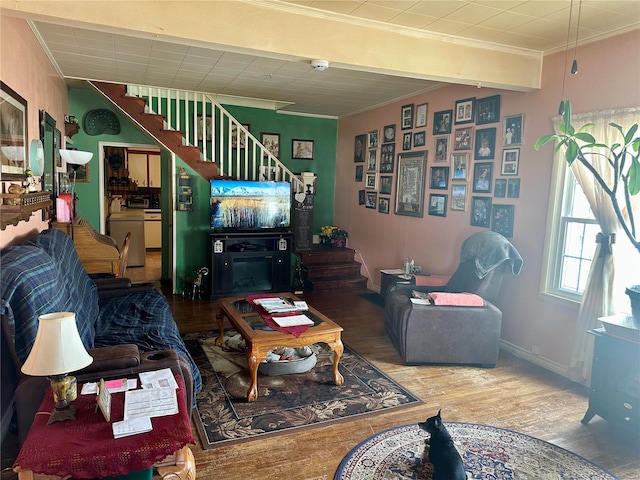 living area with ornamental molding, stairway, baseboards, and wood finished floors