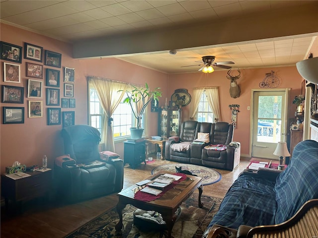 living room featuring a ceiling fan, baseboards, crown molding, and beamed ceiling