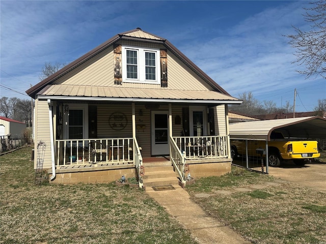 bungalow-style house with a carport, covered porch, a front yard, and metal roof