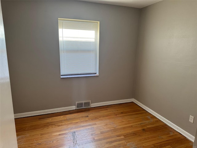 spare room with light wood finished floors, baseboards, and visible vents