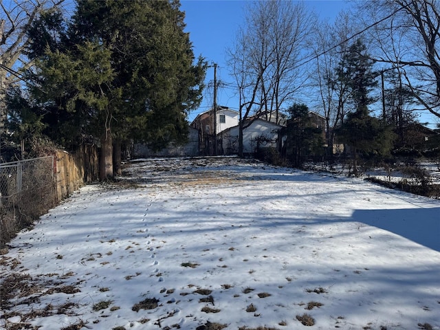 yard covered in snow featuring fence