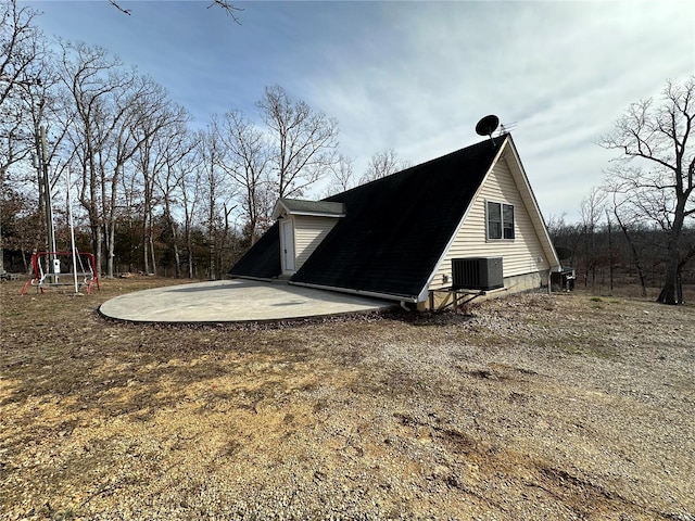 exterior space with cooling unit, a patio, and dirt driveway