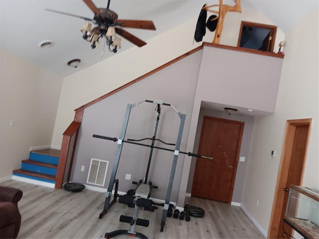 exercise room featuring ceiling fan, wood finished floors, visible vents, and baseboards