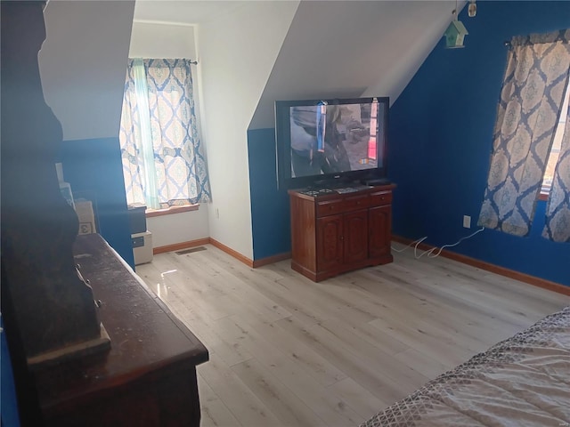 bonus room with lofted ceiling, baseboards, visible vents, and light wood-style floors