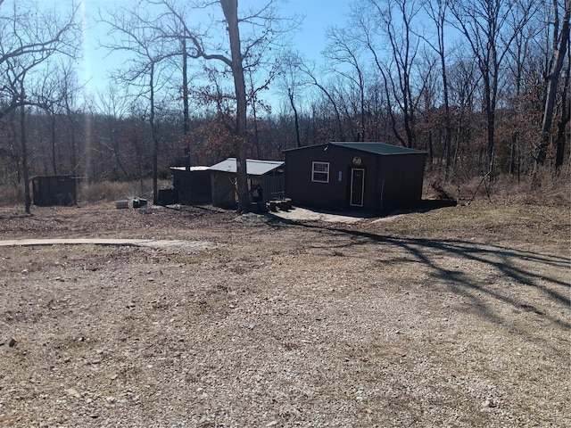 exterior space featuring a forest view and an outdoor structure