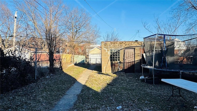 view of yard with a trampoline and fence