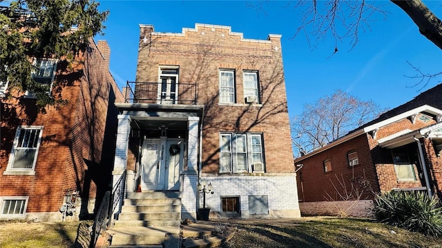 view of front of property featuring brick siding and a balcony