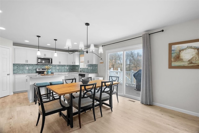 dining room featuring visible vents, baseboards, light wood-style flooring, a notable chandelier, and recessed lighting