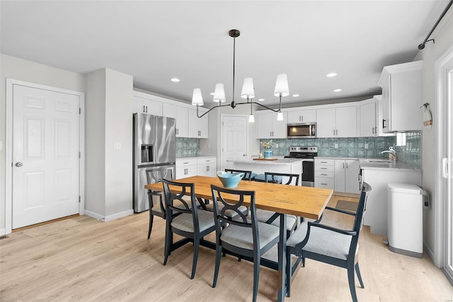 dining space with light wood-style flooring, baseboards, and recessed lighting