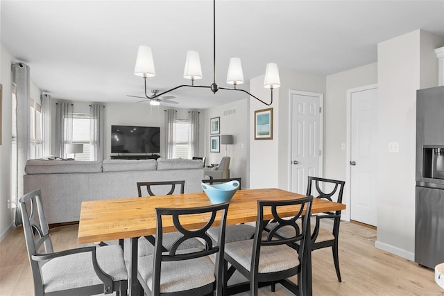 dining space featuring light wood-type flooring, visible vents, ceiling fan, and baseboards