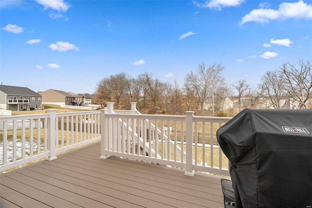 wooden terrace with a residential view and grilling area