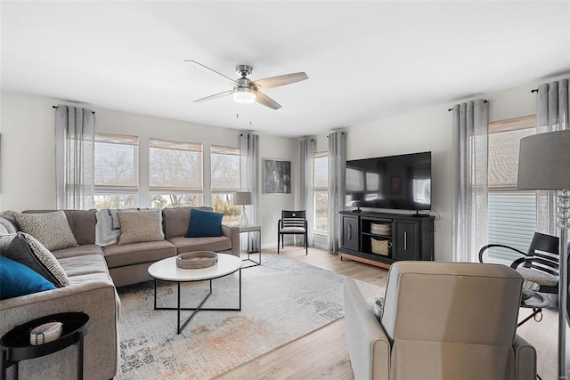 living area featuring a healthy amount of sunlight, light wood finished floors, and a ceiling fan