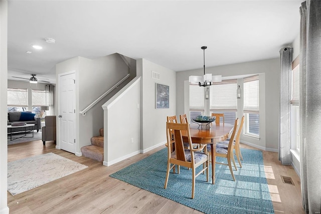 dining area featuring visible vents, light wood-style flooring, baseboards, and stairs