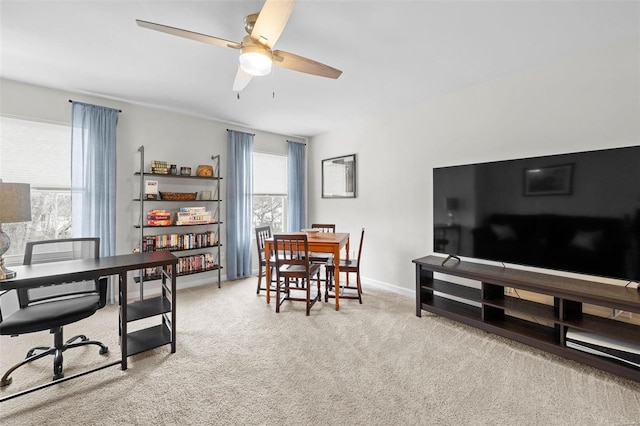 interior space featuring a healthy amount of sunlight, light colored carpet, ceiling fan, and baseboards