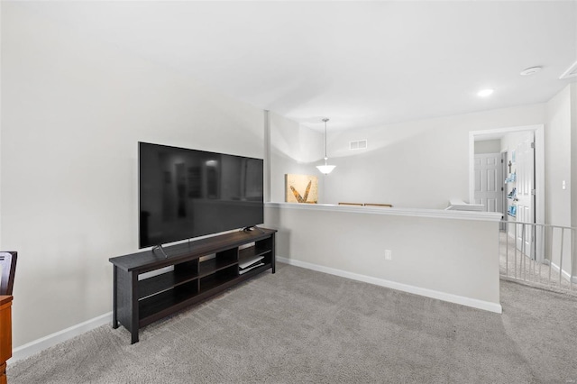 living area with light carpet, visible vents, and baseboards