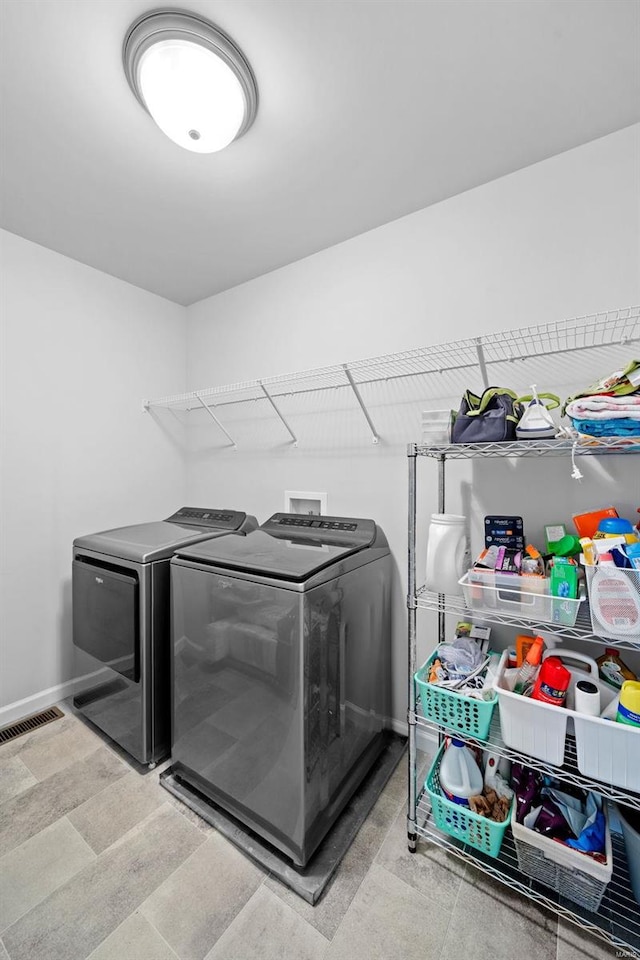 laundry area featuring laundry area, baseboards, visible vents, and washer and clothes dryer