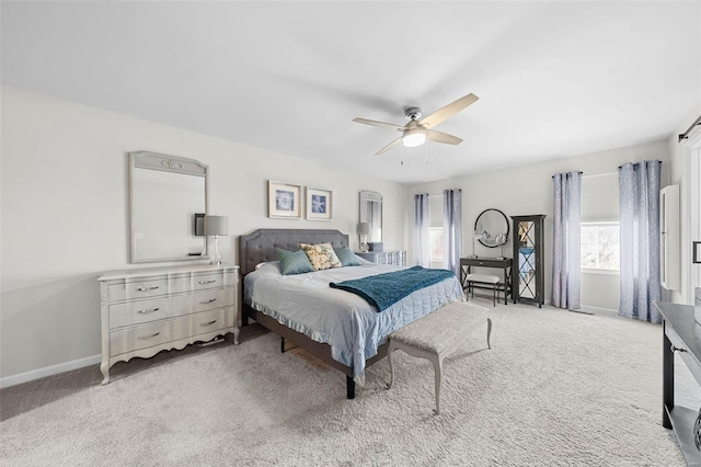 bedroom with light carpet, baseboards, and a ceiling fan