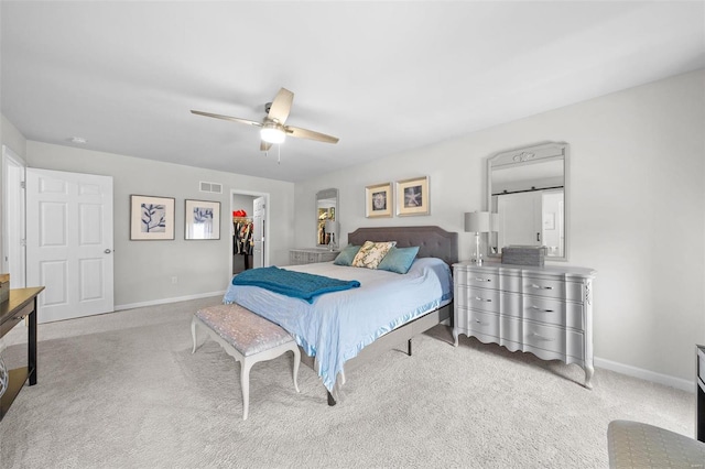 bedroom with visible vents, a spacious closet, light colored carpet, and baseboards