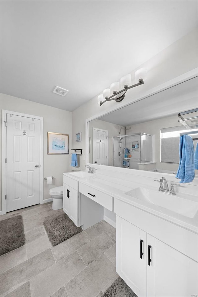 bathroom featuring double vanity, a stall shower, visible vents, toilet, and a sink