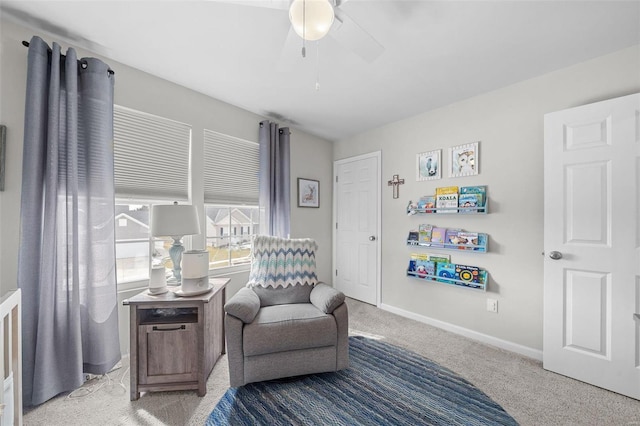 sitting room featuring ceiling fan, carpet flooring, and baseboards