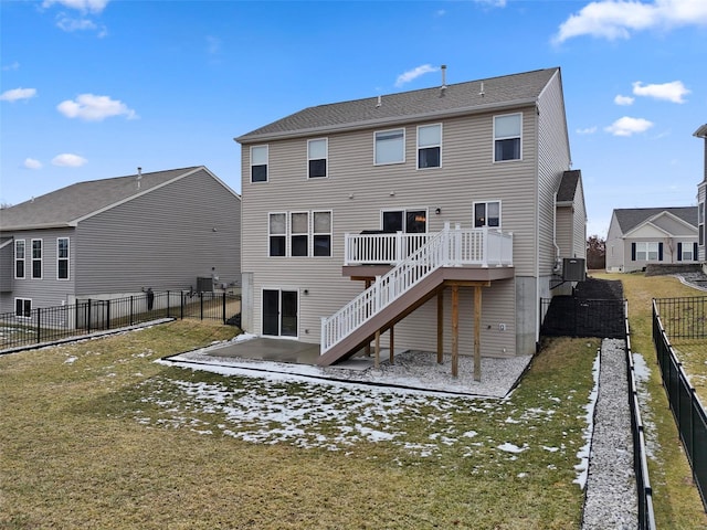 rear view of house with cooling unit, a fenced backyard, a yard, and stairway