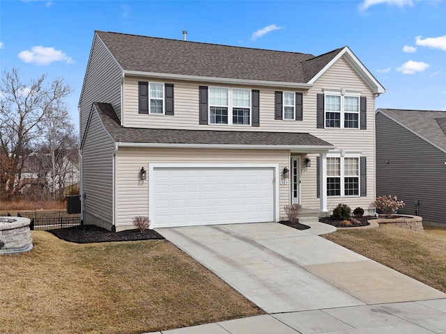 traditional-style home with concrete driveway, a front lawn, an attached garage, and a shingled roof