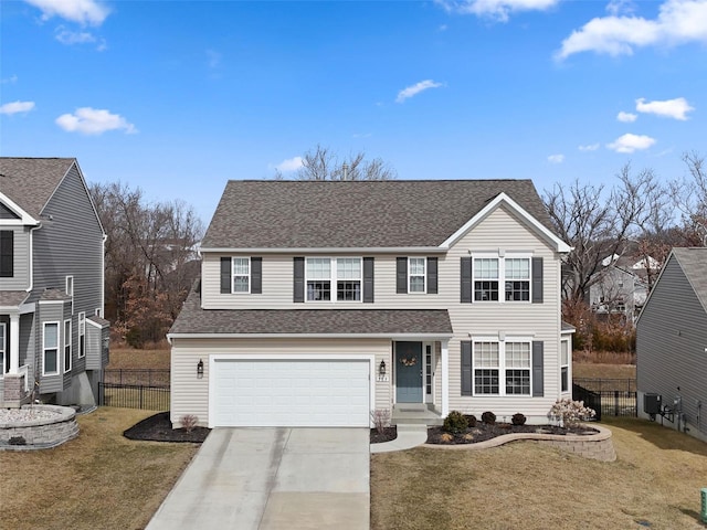 traditional-style home featuring fence, a front lawn, and concrete driveway