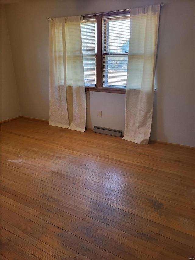 unfurnished room with light wood-type flooring and a baseboard radiator