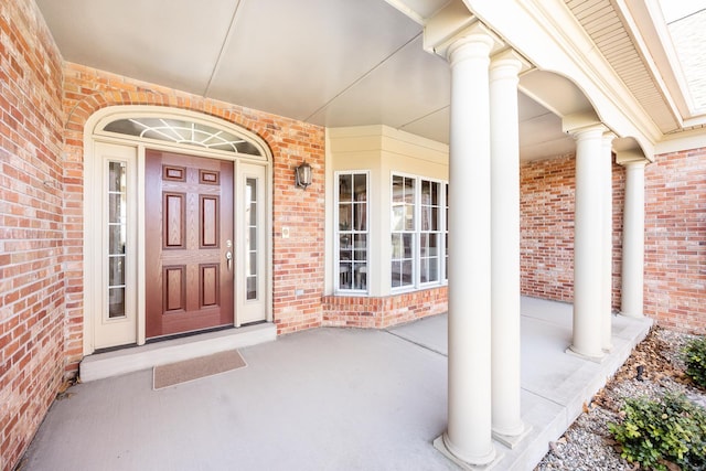 entrance to property with brick siding and covered porch