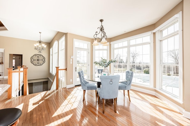 dining area featuring a chandelier, plenty of natural light, light wood-style flooring, and baseboards