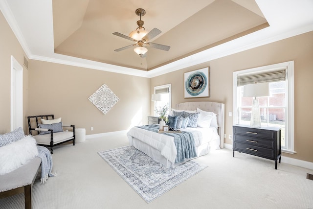 bedroom featuring a ceiling fan, baseboards, crown molding, light carpet, and a raised ceiling