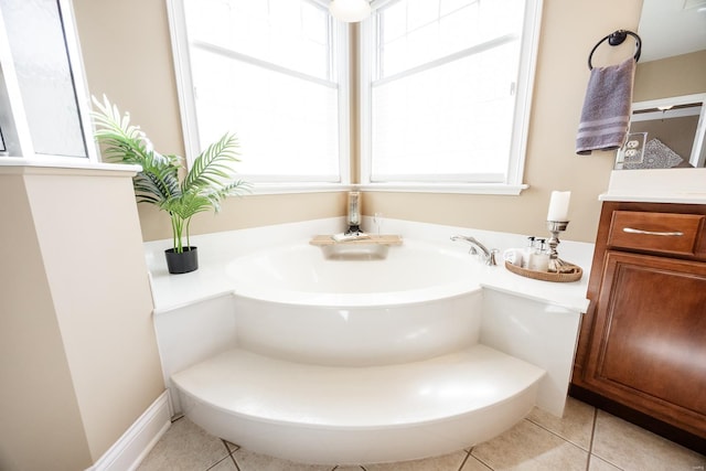 bathroom featuring tile patterned flooring, vanity, and a garden tub